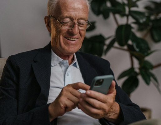 Older adult smiling at his smartphone