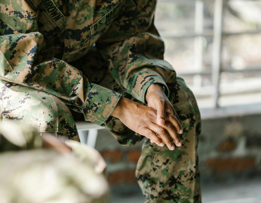 Soldier sitting down wearing camouflage uniform.