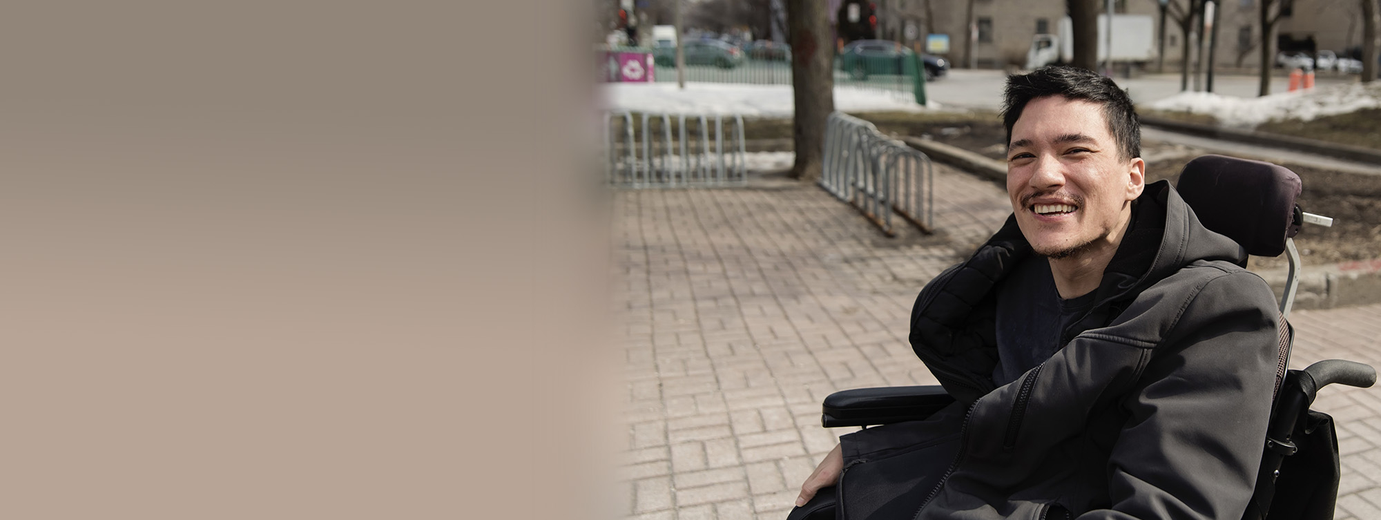 Young man using a wheelchair to commute on city street - MICPOP landing page photo