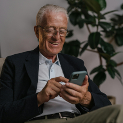 Older adult smiling at his smartphone