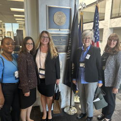 MEJI Staff posing for a photo in front of a plaque for Sen. Peters. From left to right: LaKisha Horn, Laura De Palma, Mireille Phillips, Sarah Slocum, Michelle Danou.