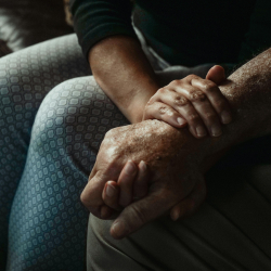 Younger adult holding an older adults arm.
