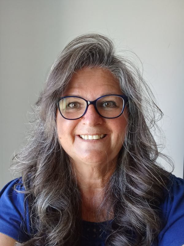 Smiling headshot of Salli Pung wearing a blue shirt and glasses